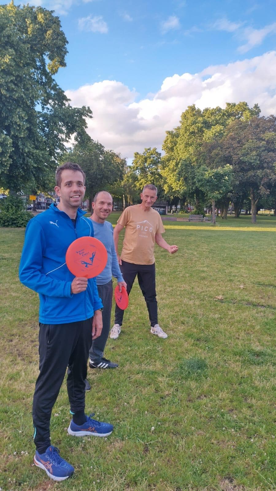 Drie spelers met frisbees tijdens een informele training